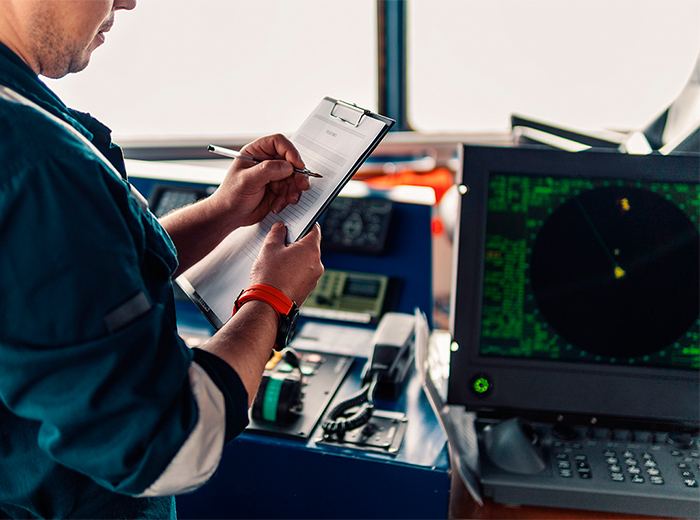 Marine officer reviewing navigation and radar equipment